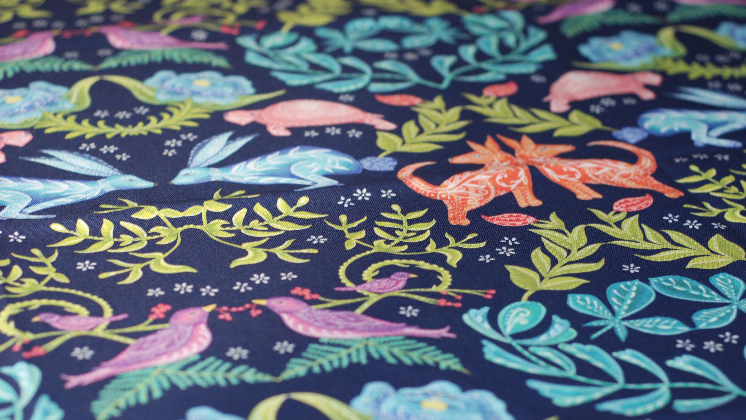 Colorful fabric with animal and nature pattern on a dark blue background